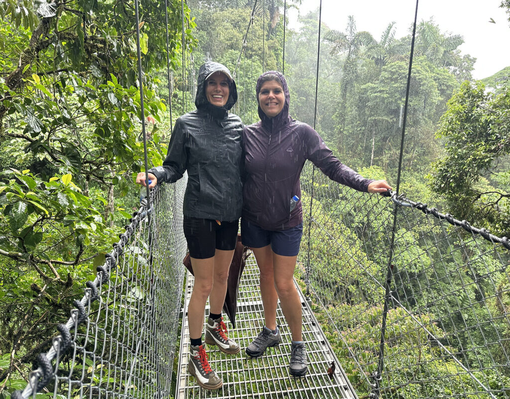 Standing on a suspension bridge in the rain surrounded by rainforest