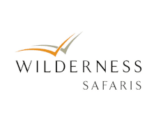 Wilderness Safaris logo with stylized bird in flight above text.