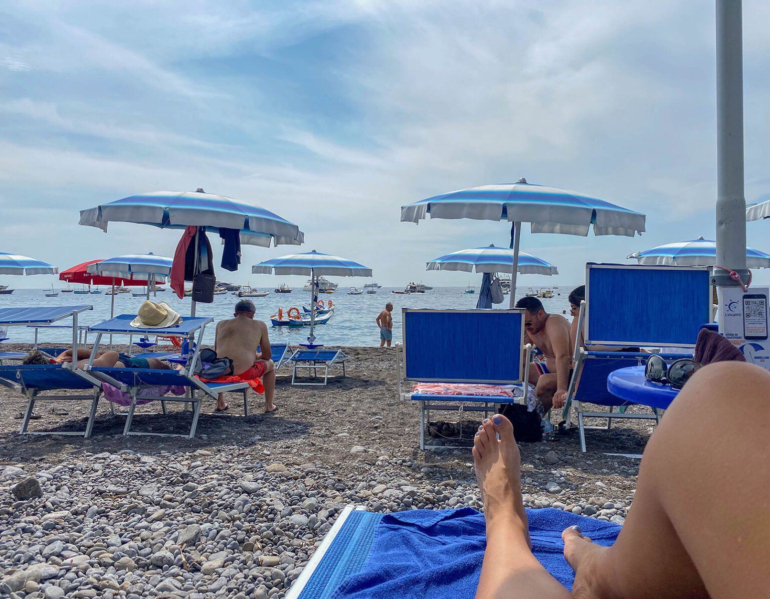 Relaxing on a pebble beach under umbrellas with a view of the sea.