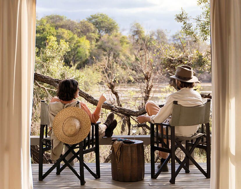 Two people sitting outdoors with guitars, enjoying nature.