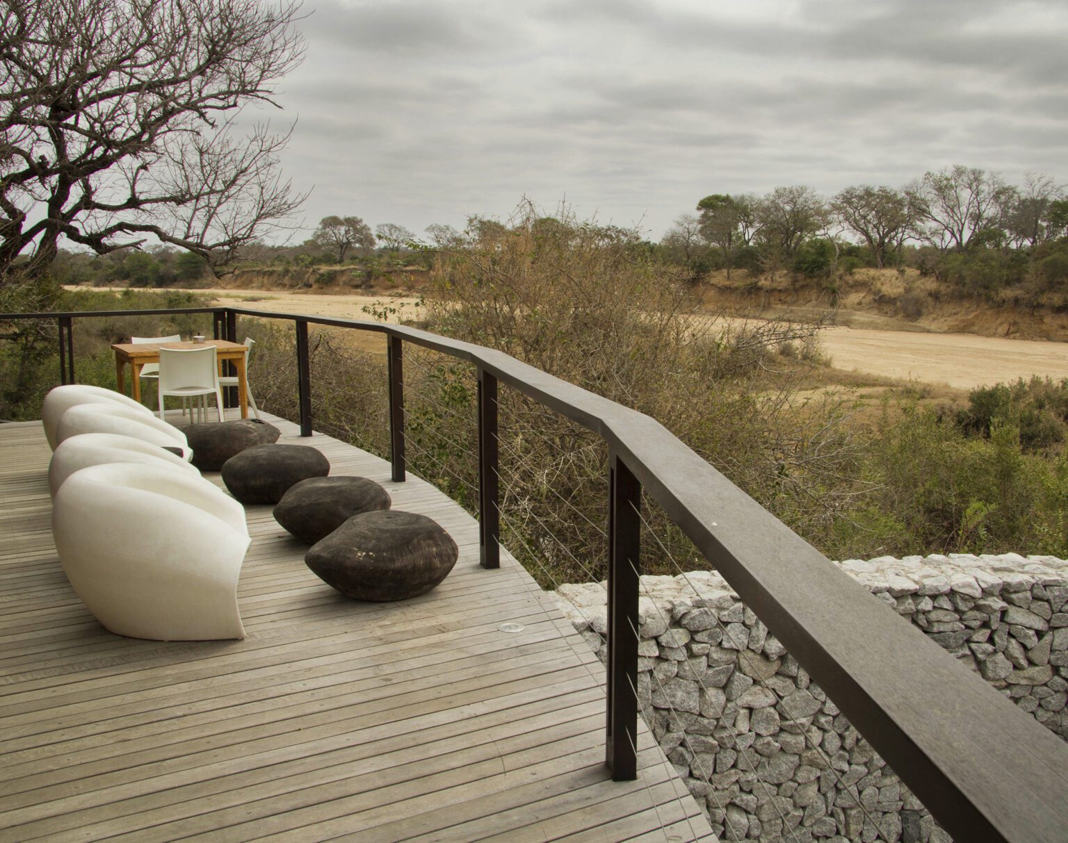Cozy outdoor seating area overlooking a natural landscape on a wooden deck.