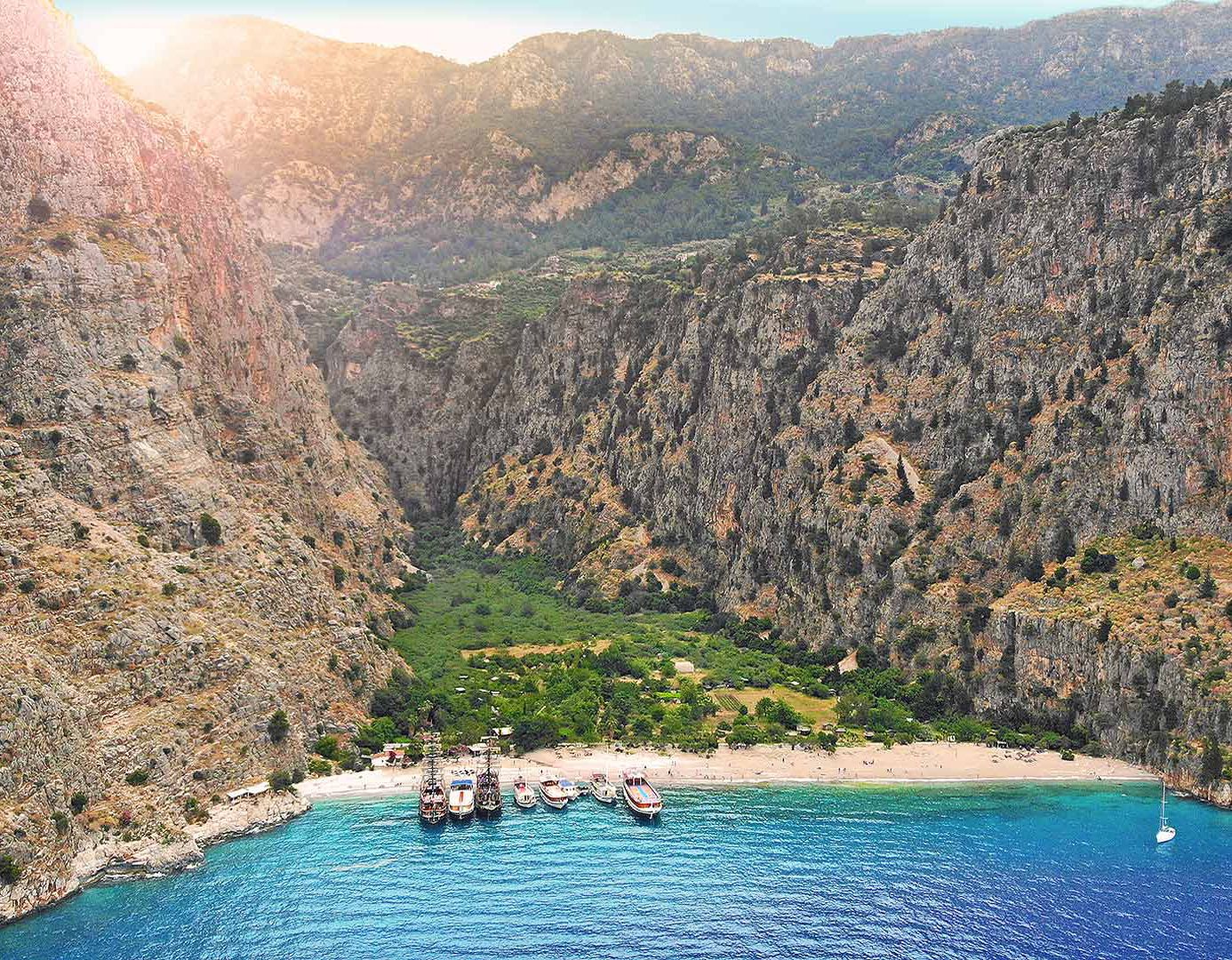 A serene coastal village nestled between rugged cliffs and clear blue waters.