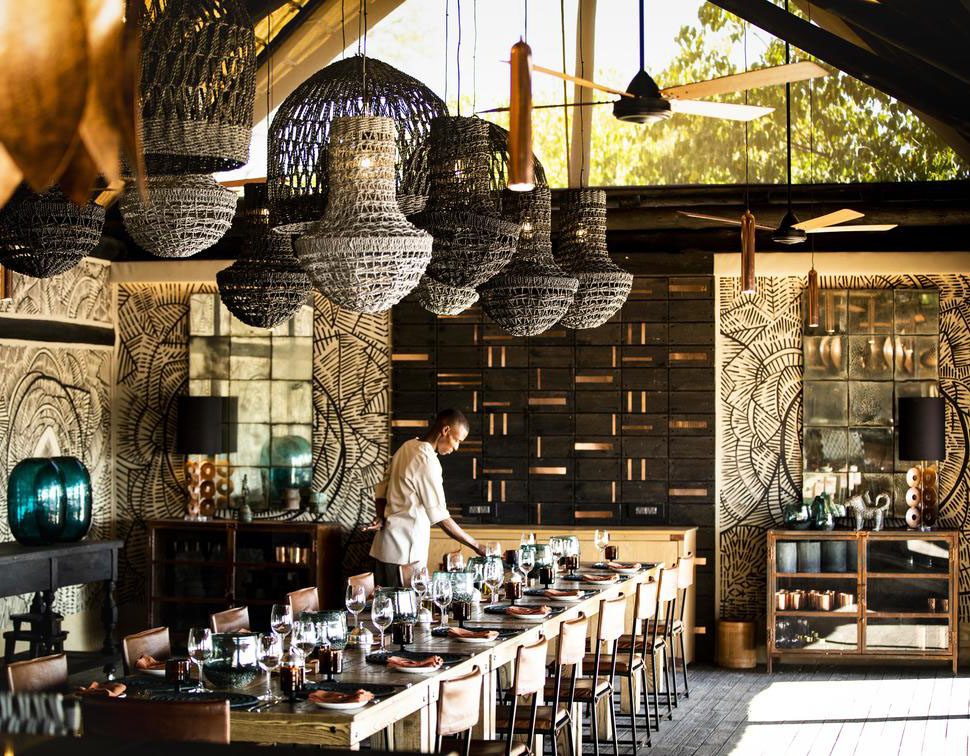 Rustic dining area with hanging lights and wooden furniture.