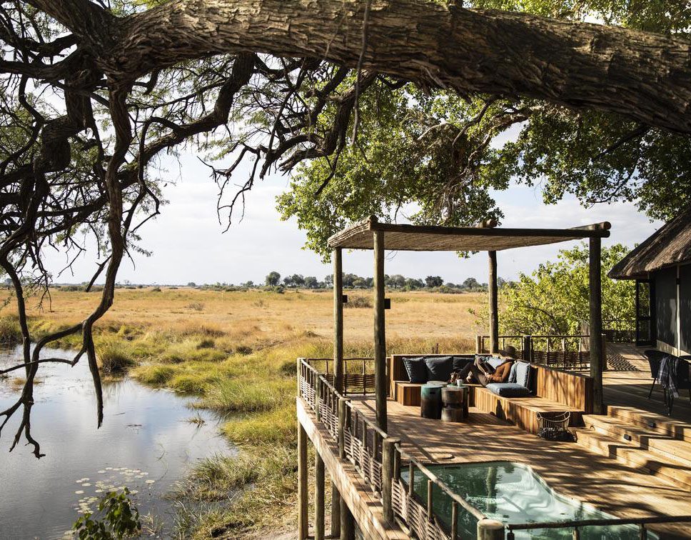 A serene outdoor dining area overlooking a water body in a natural setting.