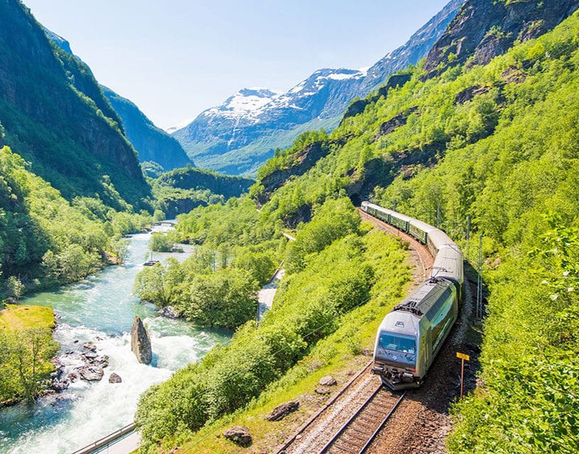 Scenic train winding through green mountain valley