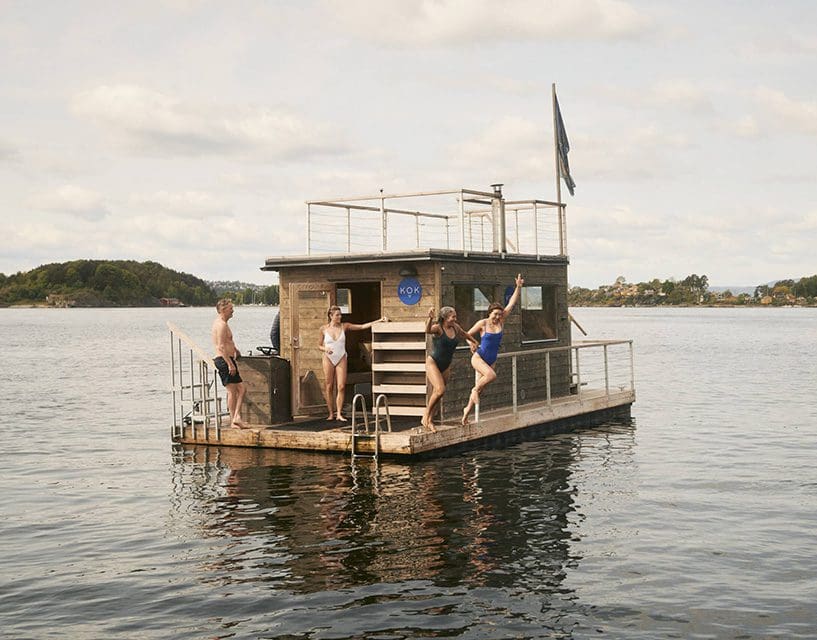 Group jumping off small wooden houseboat