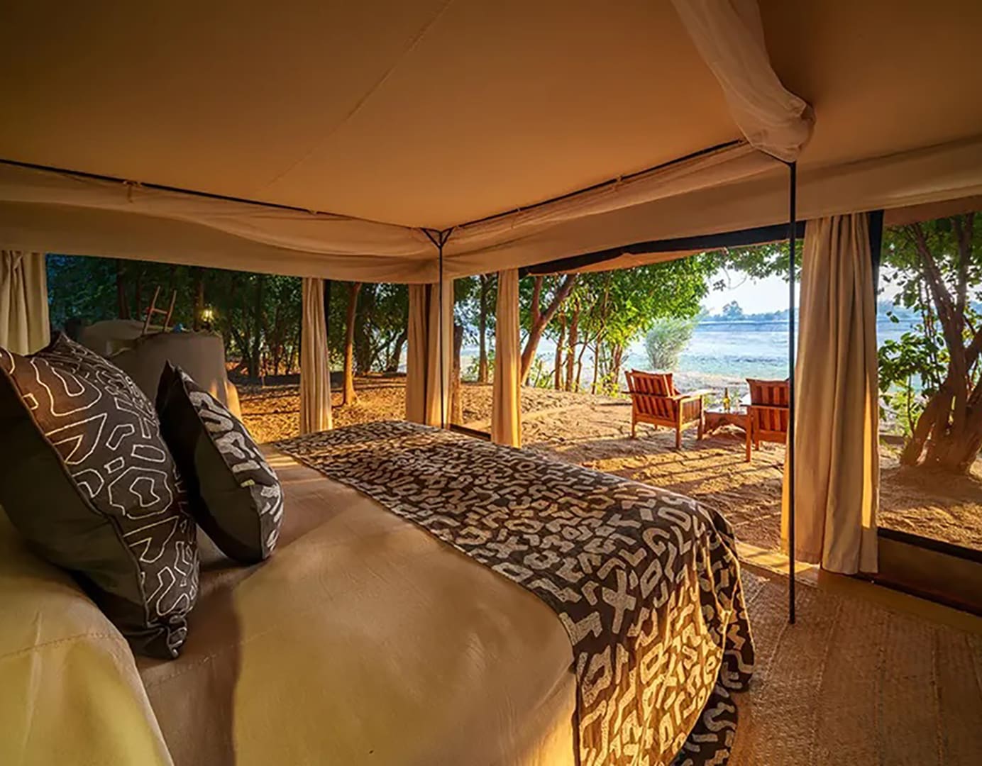 Cozy tent interior with scenic river view.