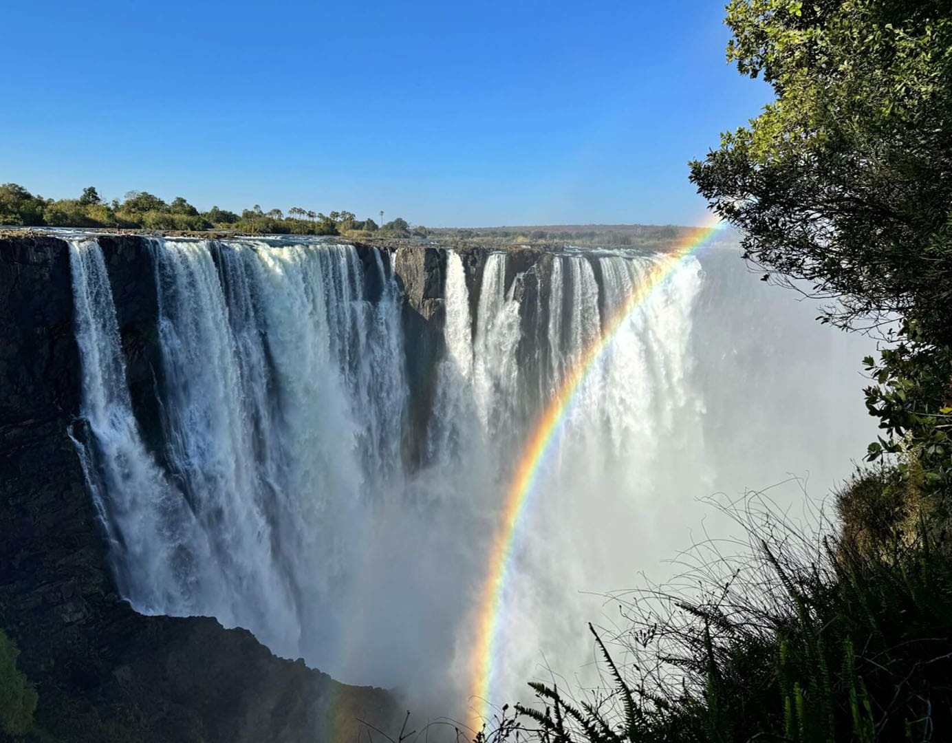 Majestic waterfall with a vibrant rainbow.